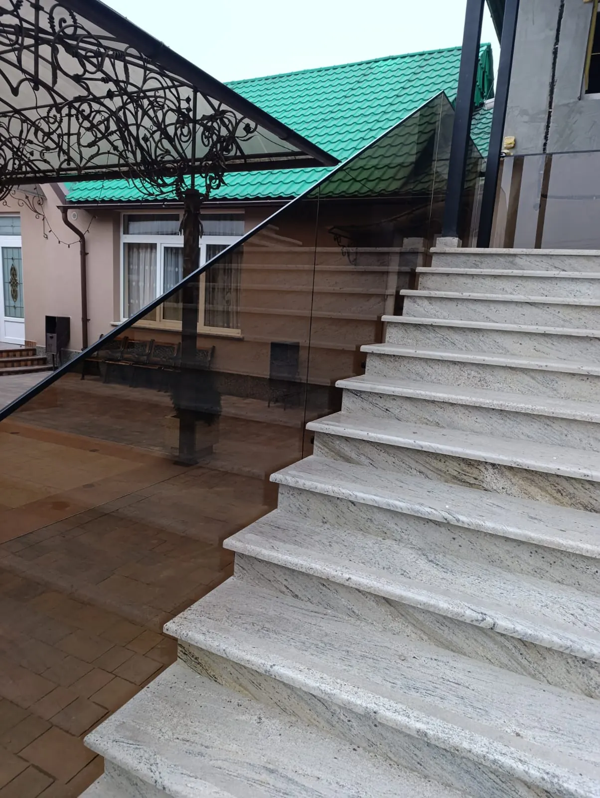 Escalera exterior de granito con cristal