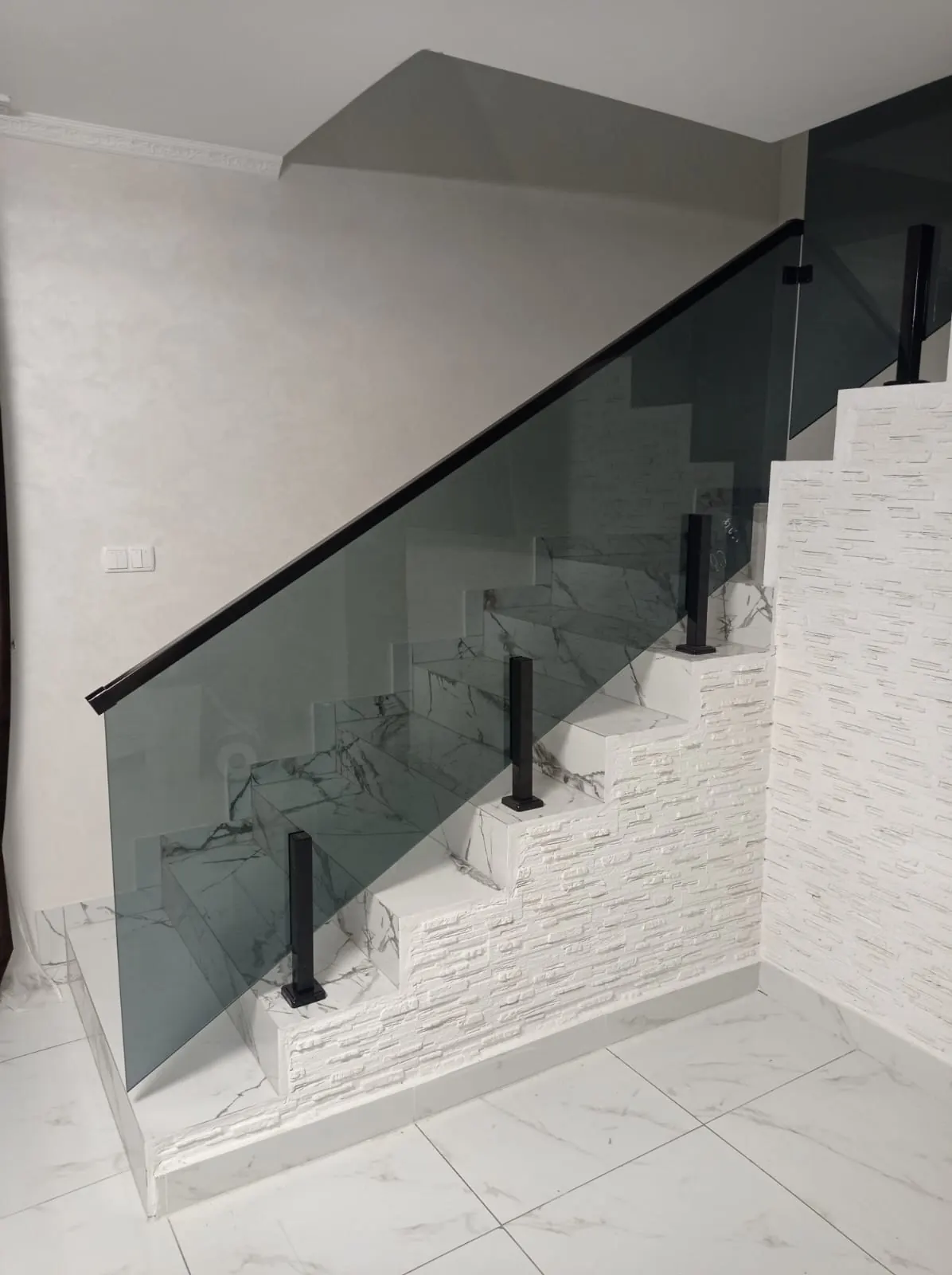 Escalera de mármol con barandilla de cristal